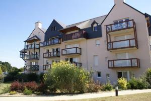 阿尔宗REF 088 Appartement T2 vue port Crouesty proche commerces的侧面有阳台的建筑