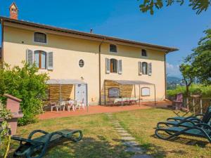 a large house with a group of benches in front of it at Apartment Crepuscolo by Interhome in Serravalle Pistoiese