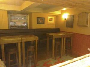 a bar with wooden stools in a room at Holland Hotel in Llanfachraeth