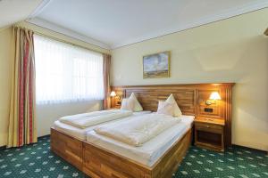 a bedroom with a large bed and a window at Golfpark Gut Düneburg in Haren