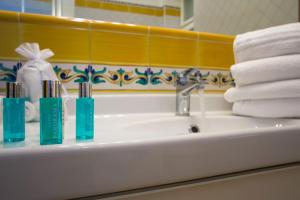 a bathroom sink with three toothbrushes and towels on it at Casa Vacanze Maiori in Maiori