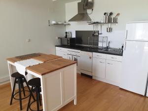 La cuisine est équipée de placards blancs et d'un réfrigérateur blanc. dans l'établissement Cozy Loft in Tres Cantos, 20 min to Madrid, à Tres Cantos