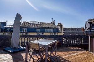 un tavolo e sedie su un balcone con vista su un edificio di Chateau Trompette - Appartement 4 chambres avec 2 salles de bain et grande terrasse a Bordeaux