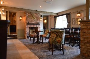 a dining room with a table and chairs and a fireplace at The Forresters Arms Kilburn in Kilburn