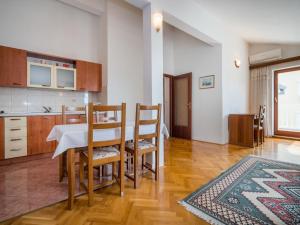 a kitchen and dining room with a table and chairs at Apartment Fuma-6 by Interhome in Jadranovo