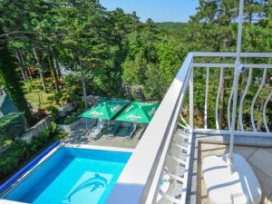 a pool with chairs and umbrellas on a balcony at Apartment Fuma-6 by Interhome in Jadranovo