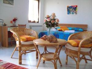 una stanza con tre sedie e un tavolo con un letto di B&B La Posada Stintino a Stintino