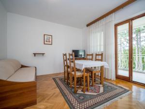 a living room with a table and chairs and a couch at Apartment Fuma-3 by Interhome in Jadranovo