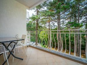 a balcony with a table and a view of trees at Apartment Fuma-3 by Interhome in Jadranovo