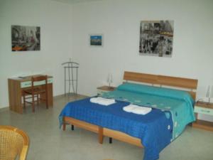 una camera da letto con un letto, un tavolo e una scrivania di B&B La Posada Stintino a Stintino