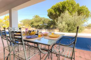 a table and chairs on a patio with a view at Villa Caramu - rustic 3 bedroom villa with private pool and great seaviews in Lagoa