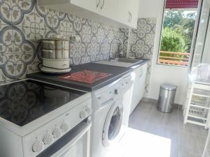 a kitchen with a stove and a washer and dryer at Apartment Du lac by Interhome in Soorts-Hossegor