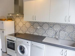 Apartment Du lac by Interhome في سورت-هوسيغور: مطبخ مع دواليب بيضاء وغسالة ونشافة