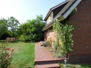 a brick house with a brick walkway next to a yard at Poseidon in Nebel