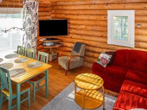 a living room with a red couch and a table at Holiday Home Kiepinkulma a by Interhome in Levi