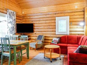 sala de estar con sofá rojo y mesa en Holiday Home Kiepinkulma a by Interhome, en Levi