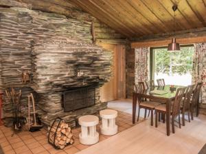 ein Esszimmer mit einem Steinkamin in einer Blockhütte in der Unterkunft Holiday Home Hallan kelo by Interhome in Ruka
