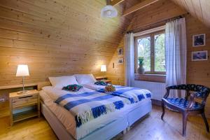 a bedroom with a bed and a wooden wall at Domek regionalny Akwarela centrum sauna in Zakopane