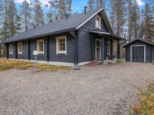 a black house with a driveway in front of it at Holiday Home Honkahovi by Interhome in Ylläsjärvi