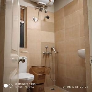 a small bathroom with a toilet and a shower at Entire Condominium Luxury Suites Perfect Getaway in Noida