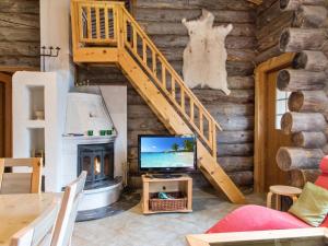 een woonkamer met een open haard en een houten muur bij Holiday Home Klasun maja a by Interhome in Ylläsjärvi