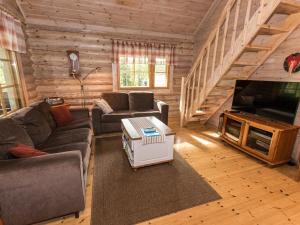 een woonkamer met een bank en een televisie in een blokhut bij Holiday Home Koivuranta by Interhome in Jämijärvi