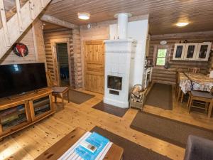- un salon avec une cheminée dans une cabane en rondins dans l'établissement Holiday Home Koivuranta by Interhome, à Jämijärvi