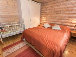 een slaapkamer met een bed en een houten muur bij Holiday Home Koivuranta by Interhome in Jämijärvi