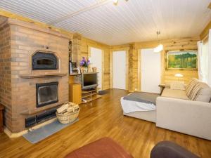 a living room with a stone fireplace and a couch at Holiday Home Viinakorpi by Interhome in Somerniemi