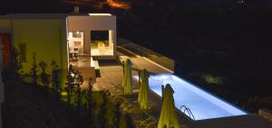 - une piscine en face d'une maison la nuit dans l'établissement Sea View Villas, à Agia Pelagia