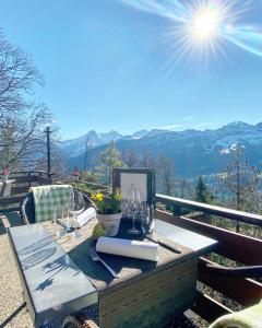 - une table avec des verres à vin et un livre sur un balcon dans l'établissement Hotel Gloria, à Beatenberg