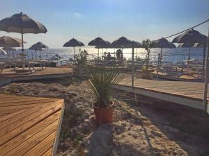 een strand met tafels en parasols en de oceaan bij Apartment Villa Anna-2 by Interhome in Andrano