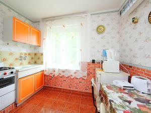 a kitchen with orange cabinets and a brick wall at Holiday Home Palma by Interhome in Balatonszárszó +8 photos