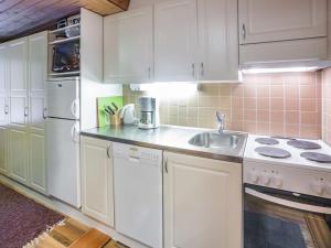 アカスロンポロにあるHoliday Home Harpan maja-mesimarja by Interhomeの白いキャビネットとシンク付きのキッチン