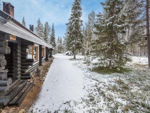 ścieżka pokryta śniegiem obok domku z bali w obiekcie Holiday Home Harpan maja-mesimarja by Interhome w mieście Äkäslompolo