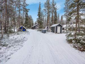 Une route enneigée menant à certaines cabanes dans l'établissement Holiday Home Harpan maja-mesimarja by Interhome, à Äkäslompolo