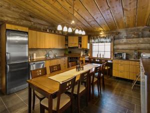 een keuken met een tafel, stoelen en een koelkast bij Holiday Home Äkäsranta by Interhome in Äkäsjoensuu +23 foto's