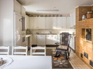 アカスロンポロにあるHoliday Home Kesänkilehto by Interhomeの白いキャビネット、テーブルと椅子付きのキッチンが備わります。