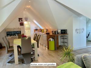 cocina y comedor con mesa en el ático en Ferienwohnung Rundblick, en Hohwacht