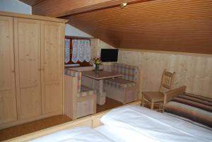 1 dormitorio con cama, escritorio y mesa en Albergo Pineta, en Castello di Fiemme