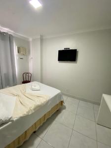 ヴィトーリアにあるHotel Sol e Marのベッドと壁にテレビが掛かった寝室