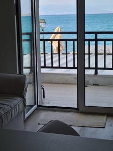 a room with a view of the ocean from a balcony at Grace Seaside in Loutraki