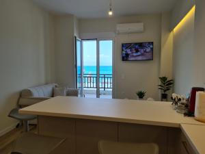 a kitchen and living room with a view of the ocean at Grace Seaside in Loutraki