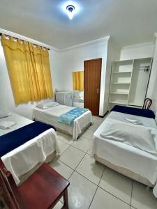 um quarto de hotel com duas camas e uma mesa em Hotel Sol e Mar em Vitória