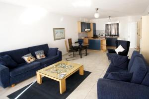a living room with two blue couches and a coffee table at Pissouri Beach Apartments in Pissouri