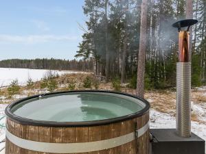 a hot tub in a wooden barrel in the snow at Holiday Home Villa mari by Interhome in Pertunmaa
