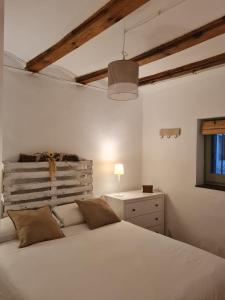 Un dormitorio con una gran cama blanca y una ventana en Cal cabironet, en Masdenverge