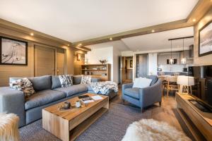 a living room with a couch and a table at Keystone Lodge by Alpine Residences in Courchevel