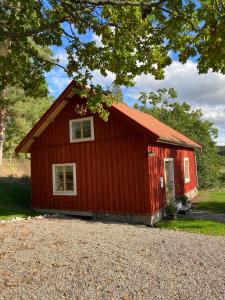 eine rote Scheune mit rotem Dach in der Unterkunft Thorstorps Gård B&B in Söderköping