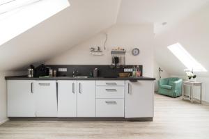 a kitchen with white cabinets and a black counter top at Gästezimmer Gutshof Bestenbostel Eine Oase der Ruhe in Wedemark